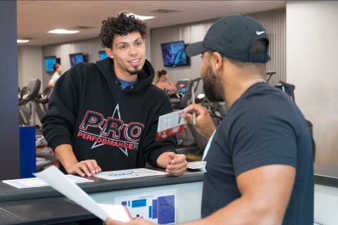 students speaking together at a gym